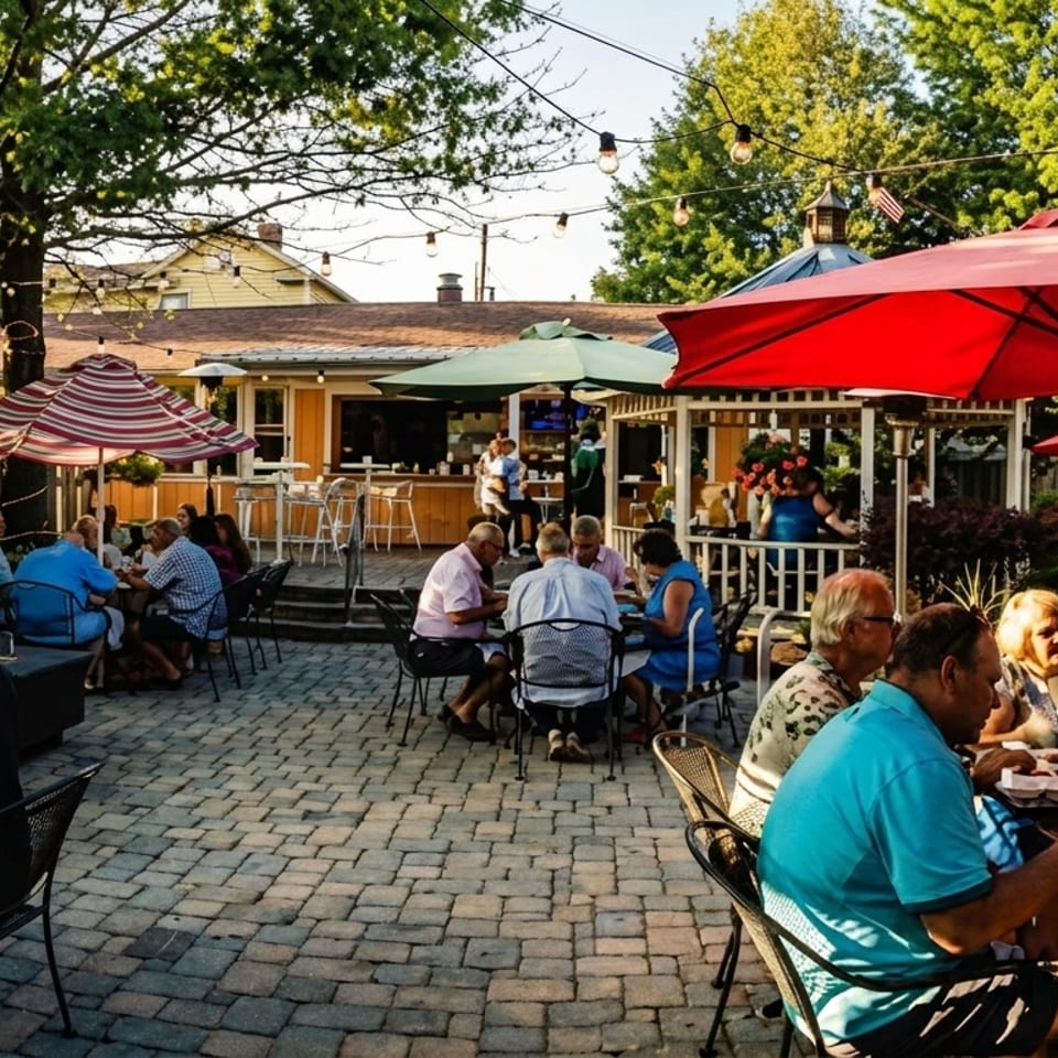 Patrons dine outdoors on a paved patio with umbrellas, string lights, and a distant bar area.